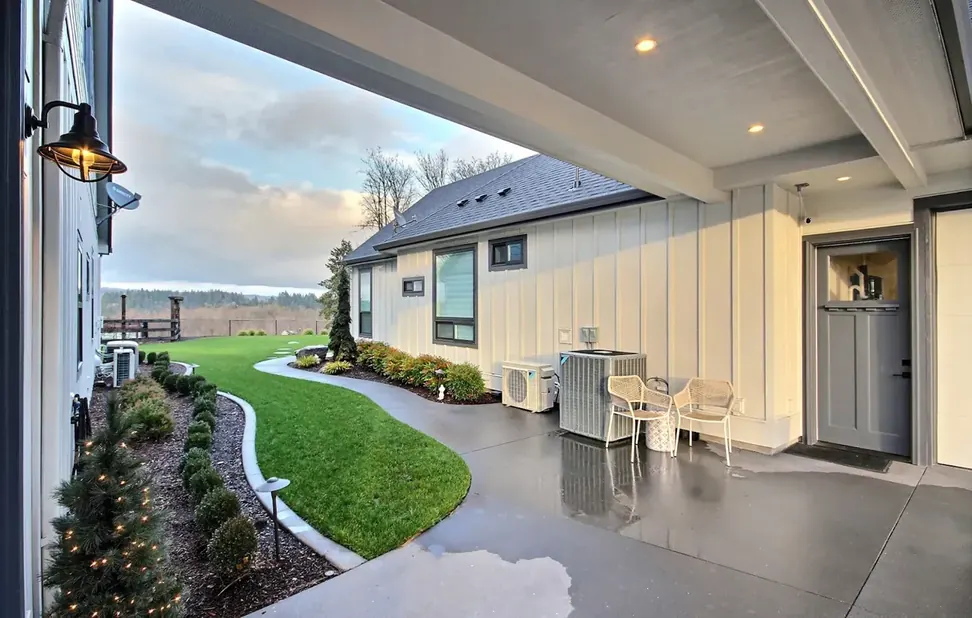 Covered patio at dusk with an air conditioning condenser installed by All Around Mechanical