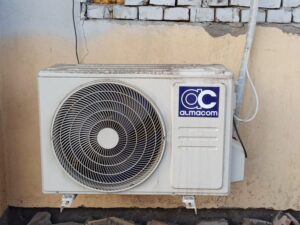 homeowner inspecting aging outdoor AC unit repair vs replacement decision - how to decide between repair and replacement